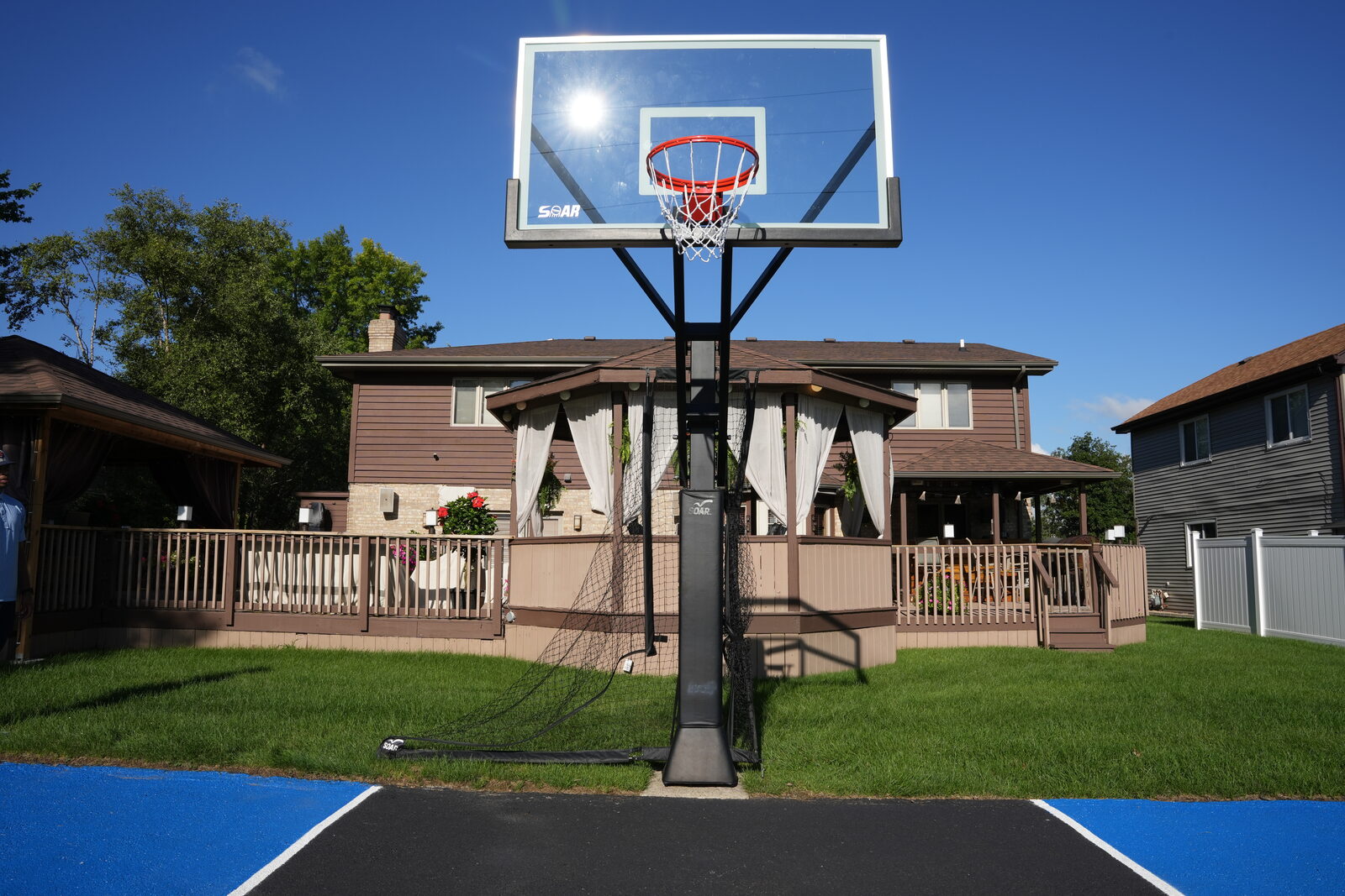 Family and friends playing on a finished residential basketball court with an in-ground hoop