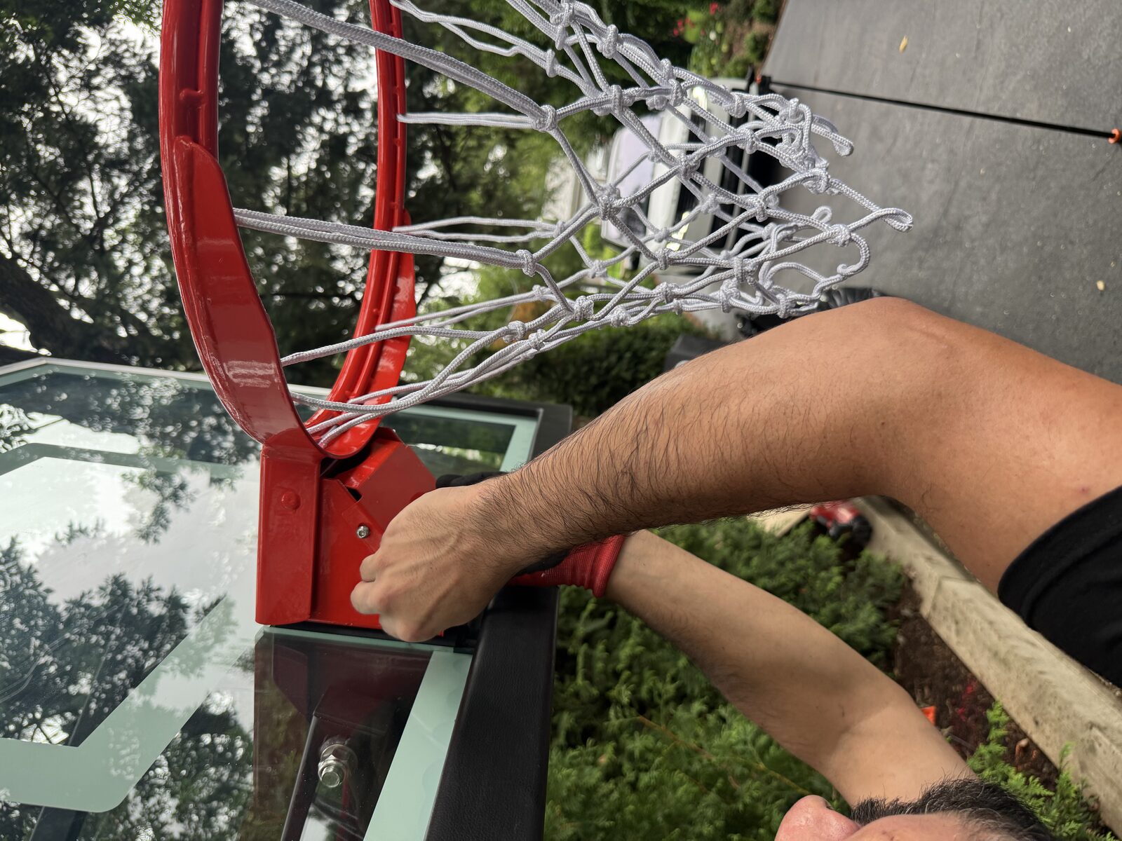 Installer attaching a new net to a basketball rim