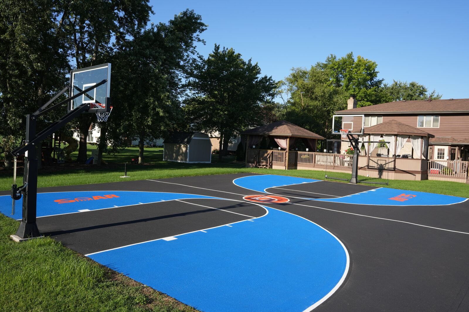 Residential basketball court with painted key, three-point arc, and boundary lines