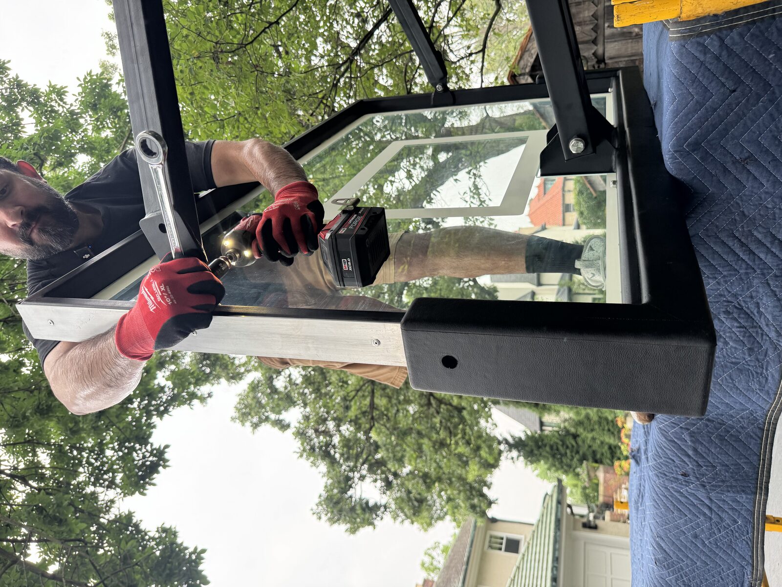 Installer using a wrench on the backboard mounting hardware of a basketball system