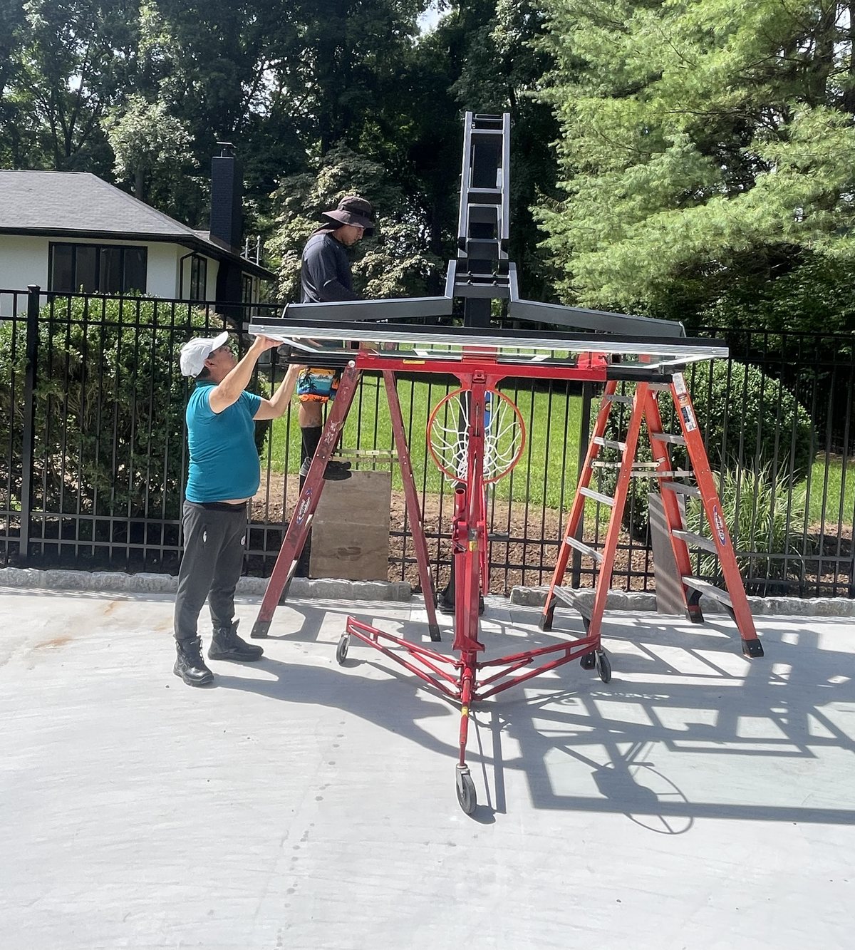 Play All Day installer working on an in-ground basketball hoop