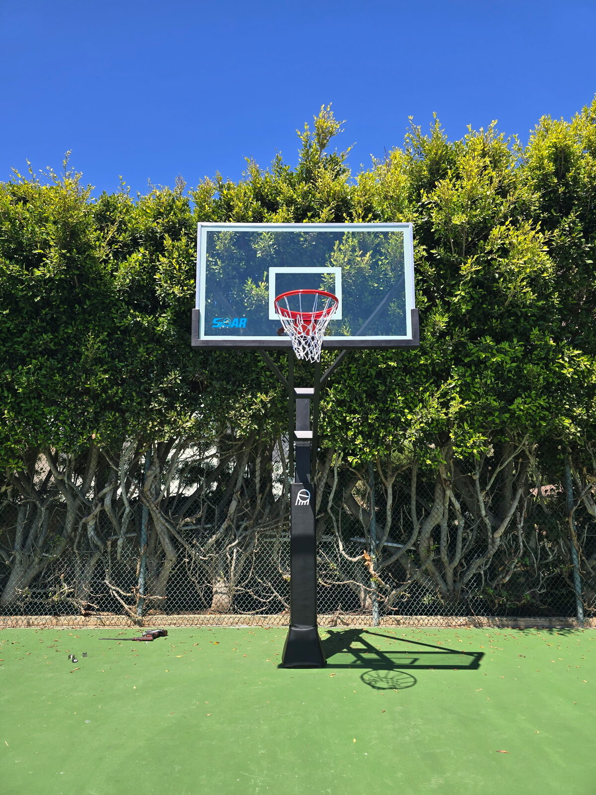 In-ground basketball hoop installed on a turf backyard court