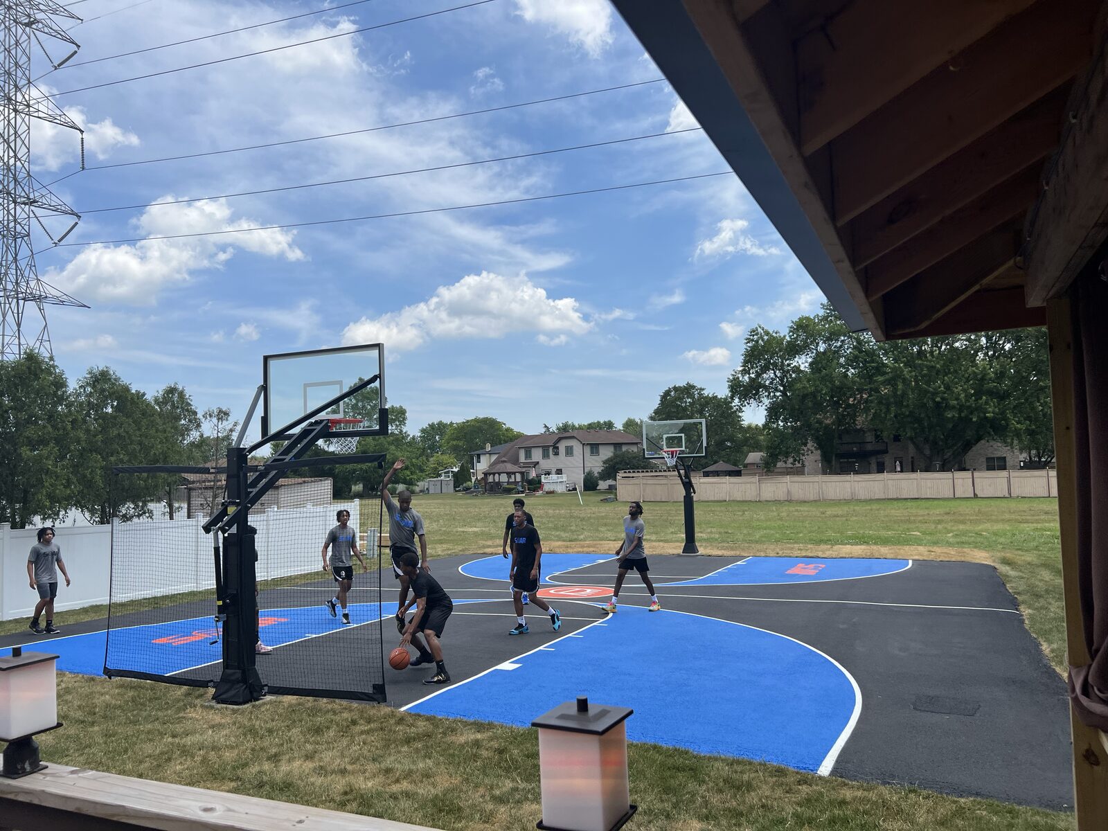 Group of players in a pickup game on a finished residential basketball court